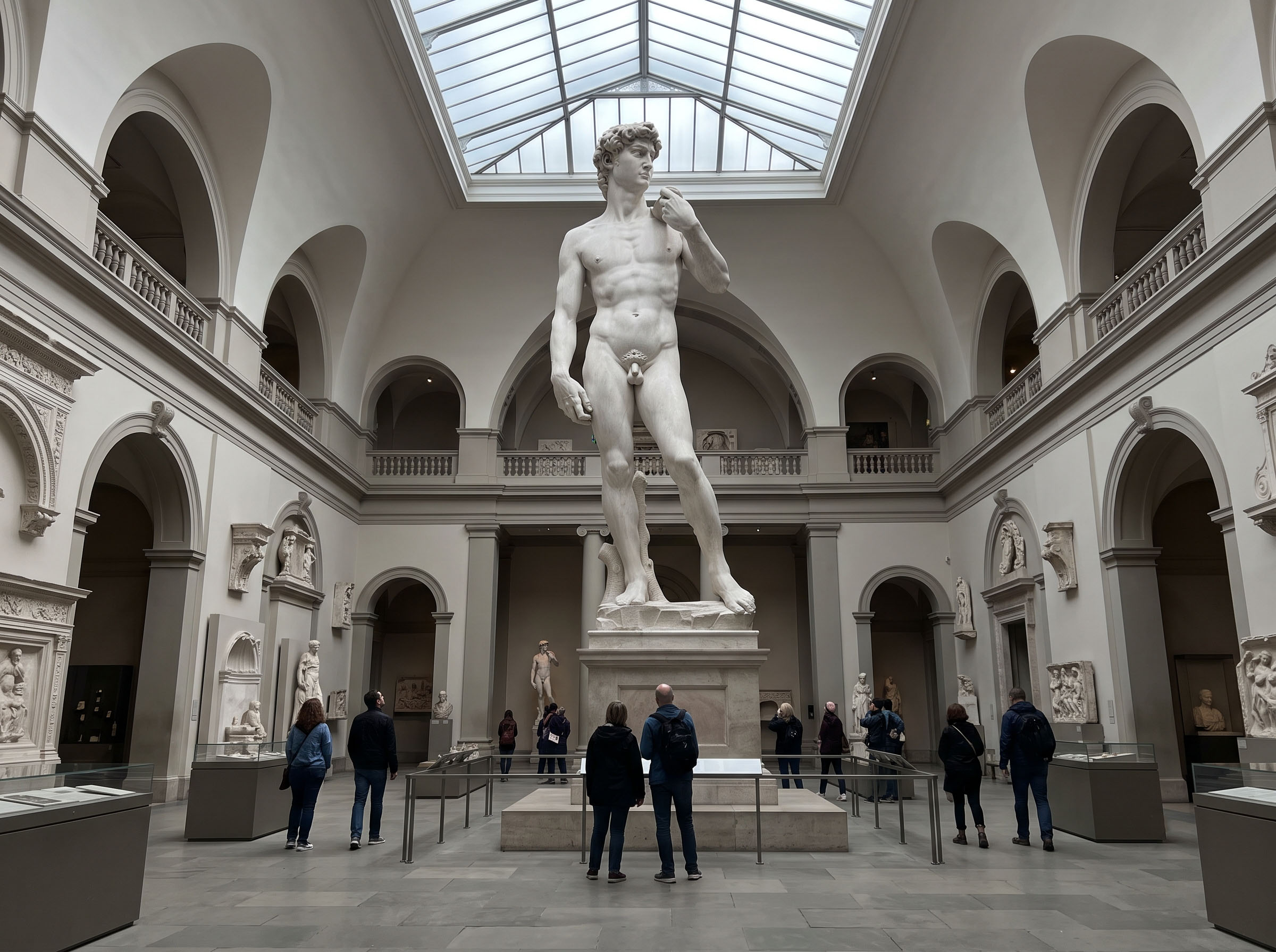 A male nude figure in a museum towering in full view of visitors