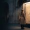 Museum visitor viewing an ancient Egyptian limestone relief of a standing figure, illustrating body ideals in Egyptian art