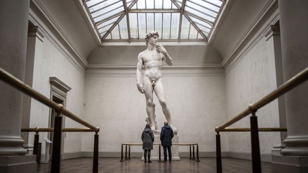 Museum cast court with a towering Renaissance nude sculpture under a skylight, illustrating how art recorded body ideals rather than measured averages