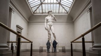 Museum cast court with a towering Renaissance nude sculpture under a skylight, illustrating how art recorded body ideals rather than measured averages