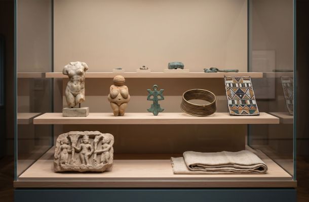 Museum vitrine of body-related artifacts from cultures around the world, illustrating how ideals of the human form have changed across history.