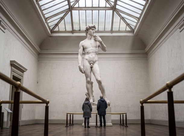 Patio de museo con un imponente desnudo escultórico renacentista bajo un tragaluz, que ilustra cómo el arte registraba ideales corporales en lugar de promedios medidos