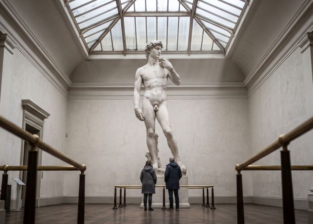 Patio de museo con un imponente desnudo escultórico renacentista bajo un tragaluz, que ilustra cómo el arte registraba ideales corporales en lugar de promedios medidos
