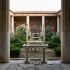 Sunlit Roman peristyle garden courtyard with marble colonnade, clipped hedging and a central water basin, the kind of enclosed garden Greco-Roman guardian figures were set to protect